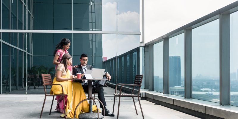 Three Indian business people with worried facial expression talking during break at work